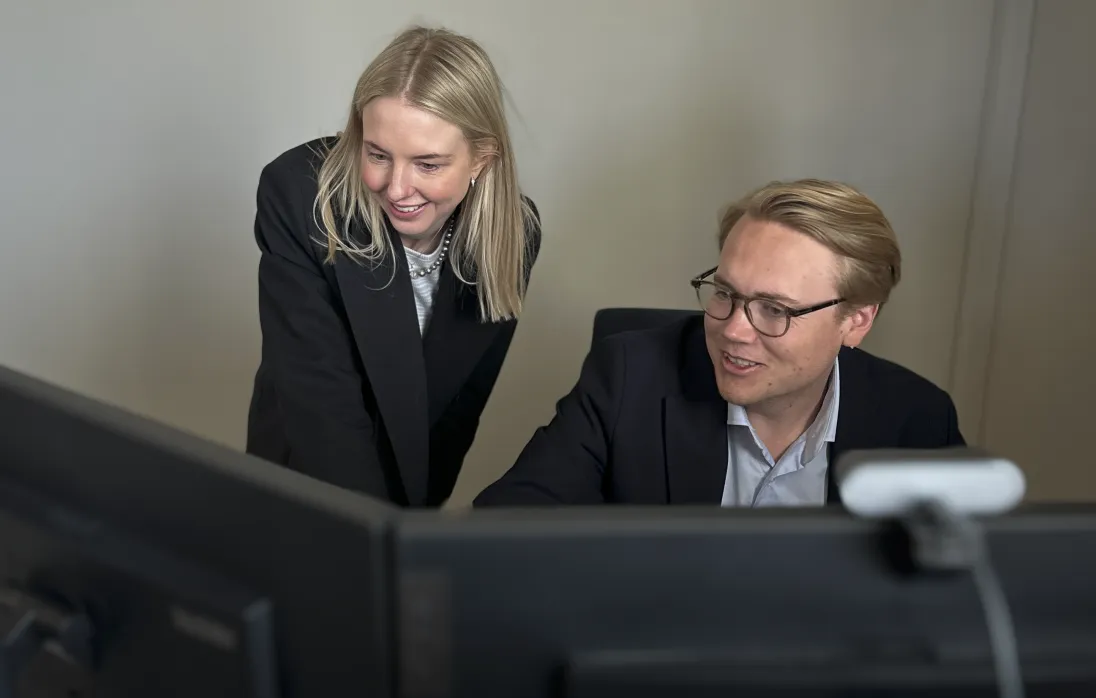 Bilde av to personer som jobber foran PC